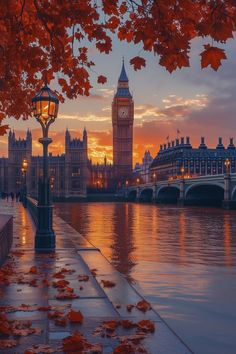 the big ben clock tower towering over the city of london at sunset with red leaves on the ground