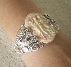 Three Muses Cuff Bracelet This beautiful silver plated filigree cuff bracelet has silver plated filigree accents and a three muses resin cameo.  Adjustable. This bracelet can be adjusted by gently squeezing for a smaller size or gently pulling it out for a larger size. victorian art nouveau edwardian art deco graces style Opal Cuff Bracelet, Wicca Jewelry, Crystal Ball Necklace, Victorian Bracelet, Wiccan Necklace, Bijoux Art Nouveau, Gothic Bracelet, Nouveau Jewelry, Goddess Jewelry