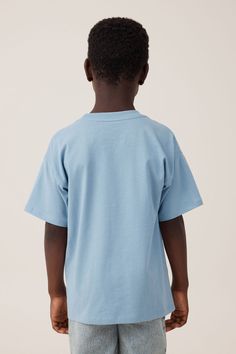 License Drop Shoulder Short Sleeve Tee Light Blue Relaxed Fit Pre-shrunk T-shirt, Blue Graphic Tee With Character Print, Blue Character Print Graphic Tee, Blue T-shirt With Character Print In Relaxed Fit, Light Blue Graphic Print T-shirt With Relaxed Fit, Cotton T-shirt With Character Print, Relaxed Fit, Blue T-shirt With Character Print For Streetwear, Light Blue Crew Neck T-shirt With Character Print, Relaxed Fit Tops With Character Print And Short Sleeves