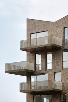 a tall brick building with balconies and windows