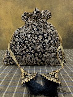 "Black silk Indian potli bag with heavy gold hand embroidery sequence work and black tassels. Wedding favor drawstring gifting bag or purse. Material: Silk with heavy gold embroidery Size: 10\" (h) x 9.5 \" (w) This beautifully embroidered potli bag will enhance any of your outfits! The design is delicately hand   embroidered in  pale gold metallic flowers on black silk. And it's perfect for Indian weddings, as return gifts or as a gift bag!" Festive Evening Bags With Tassels, Festive Gold Bag With Tassels, Festive Celebration Bags With Tassels, Festival Potli Bag With Tassels For Party, Elegant Festive Bags With Tassels, Elegant Festive Tassel Bags, Festive Party Bags With Tassels, Gold Potli Bag With Tassels For Festivals, Festive Elegant Potli Bag With Tassels