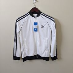 Addidas Junior Track Jacket M White/Black New With Tags. Zip Up White Cotton Track Jacket For Fall, White Casual Track Jacket With Ribbed Cuffs, Casual White Track Jacket With Ribbed Cuffs, Adidas White Track Jacket For Winter, White Cotton Track Jacket In Sportswear Style, White Casual Track Jacket For Fall, White Cotton Track Jacket For Spring, White Adidas Track Jacket For Winter, Casual Fitted White Track Jacket