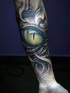 a man's arm with an eye and snake tattoo on the inside of it