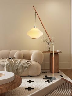 a living room filled with furniture and a lamp on top of a wooden table in front of a white wall