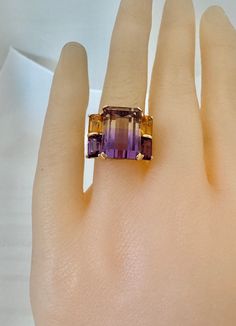 14K Solid Gold 9ctw Ametrine Emerald Stepped Cut Accent 2 Citrine 2 Amethyst Step Cut Yellow Gold Unique Ring  6.75 Grams Size 7 Ring Lovely Length: 0.56" x 0.71" Weighs:  grams approx carat 9ctw Ametrine natural gemstone a formation of gem created when purple amethyst and golden citrine grow in to the same crystal. Band of yellow and purple bisect this gorgeous ring. Visit our Etsy shop's  HauteCoutureLaLa  TrendsCouture  BorrowedTrends  BeautifulPatina  LastingTrends Free Shipping on orders ov Luxury Multi-stone Yellow Gold Amethyst Ring, 7 Ring, Gorgeous Ring, Yellow And Purple, Wedding Brooch, Step Cut, Unique Ring, Pendant Rings, Art Deco Jewelry