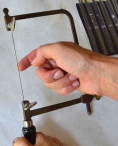 a person is working on some type of object with metal parts attached to the handle