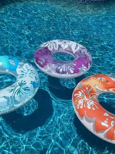 three inflatable floats floating on top of a swimming pool