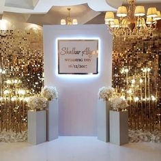 the entrance to an event with gold sequins on the walls and flowers in vases