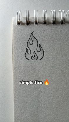 a spiral notebook with a simple fire sticker on the front and back cover that reads, simple fire