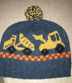 a blue hat with yellow and red designs on the front, sitting on top of a white surface