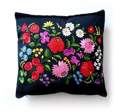 a black pillow with colorful flowers on it