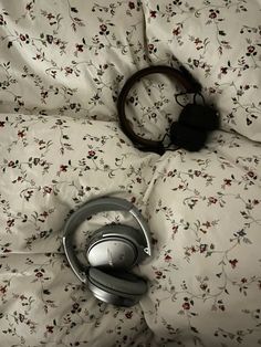 the headphones have been placed on top of the comforter, which is covered with floral fabric