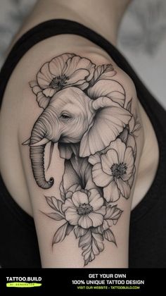 an elephant and flowers tattoo on the back of a woman's shoulder, it is black and white