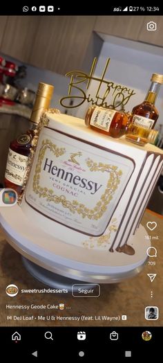 a cake that is sitting on top of a table with liquor bottles in front of it