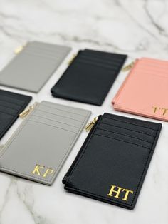 four personalized leather wallets sitting on top of a marble counter