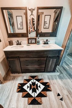 a bathroom with two sinks, mirrors and rugs on the floor in front of it