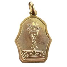 A French 18 karat (18K) yellow gold charm pendant depicting a chalice surmounted with a wafer, representing the First Communion. Engraved to the reverse 'Souvenir de 1re Communion'. Stamped with the eagle's head for French manufacture and 18 karat gold. Dimensions: 2.6 x 1.9 x 0.05 cm (not including jump ring) Weight: 1.32 grams  (Chain not included) Eagle Head, Gold Medal, First Communion, Gold Charm, Jump Rings, Pendant Necklaces, Charm Pendant, Jewelry Necklace Pendant, Jewelry Necklaces