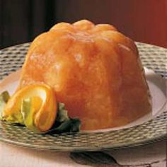 a bundt cake on a plate with oranges and lettuce around it