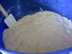 a blue bowl filled with flour and a wooden spatula