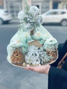 a person holding a basket filled with nuts and flowers