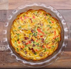 a pizza sitting on top of a metal pan covered in cheese and veggies