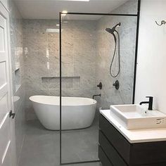 a white bath tub sitting next to a walk in shower