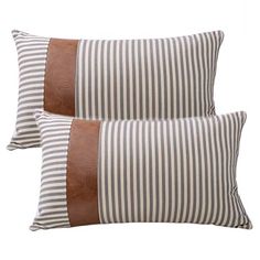 two brown and white striped pillows sitting next to each other