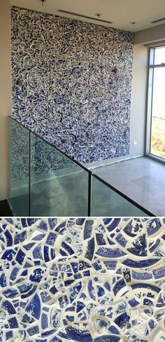 an artistic blue and white tile wall next to a glass railing