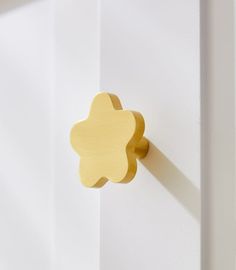 a close up of a door handle on a white door with a yellow flower design