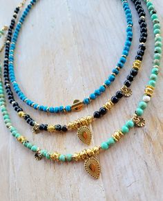 Choose from 3 gorgeous boho necklaces.   Length : 16" + 5cm extender chain Beads: 4mm 1. Blue howlite with 18k gold plated beads, centre bead and fastenings.  2. Sea shell and synthetic black turquoise gemstone beads with 18k gold plated beads, pendants, charms and fastenings.  3. Sea shell and synthetic green turquoise gemstone beads with 18k gold plated beads, pendants, charms and fastenings. Pendant: 9mm x 18mm Charms: 4.7mm x 7.5mm ✨️Care for your jewellery by avoiding perfumes and lotions w Bohemian Crystal Necklace With Round Beads And Adjustable Chain, Bohemian Blue Round Beads Charm Necklace, Bohemian Necklace With Adjustable Chain And Round Beads, Bohemian Gold Charm Necklaces With Gemstone Beads, Bohemian Charm Necklaces With Round Natural Stones, Bohemian Gold Charm Necklace With Gemstone Beads, Bohemian Charm Necklaces With Natural Stone Round Beads, Bohemian Gold Charm Necklaces With Colorful Beads, Bohemian Gold Charm Necklace With Colorful Beads