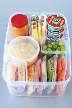 a plastic container filled with different types of food and condiments on top of it