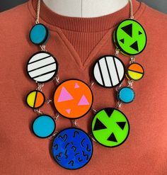 Patterned necklace is a quirky, fun accessory. It would look great as a statement piece to complete your everyday outfit. The necklace is made from multiple pieces of coloured perspex. These are layered on a clear background and have a bold black outline. They are all linked to a curb chain using jump rings.  If you have any questions drop us a line.💌 We are more than happy to help.😁 To clean your necklace you can simply wipe with a glasses cloth or soft cloth to remove finger marks. Acrylic is a fragile material so please store in a jewellery box to prevent damage.  As ever for safety please keep away from small children. Fun Multicolor Plastic Necklace, Trendy Handmade Resin Necklace, Trendy Resin Necklaces For Party, Handmade Bold Jewelry For Party, Retro White Necklace For Party, White Retro Party Necklace, Multicolor Plastic Jewelry For Party, Handmade Bold Resin Jewelry, Bold Handmade Resin Jewelry