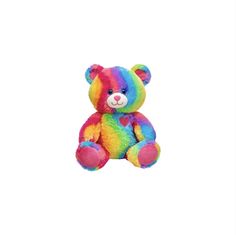 a rainbow colored teddy bear sitting up against a white background