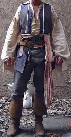 a man dressed in pirate costume standing next to a building