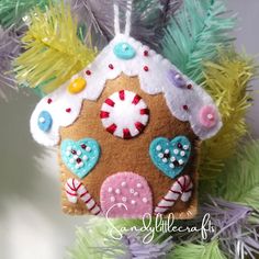 a gingerbread house ornament hanging from a christmas tree