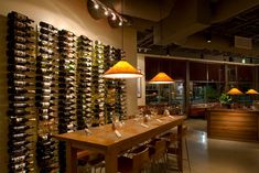 a wine cellar filled with lots of bottles and glasses on top of a wooden table