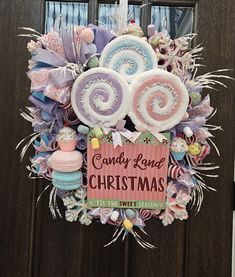 a wreath with candy and christmas decorations hanging from it's side on a door