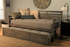 a day bed with pull out trundle and storage underneath it in a living room