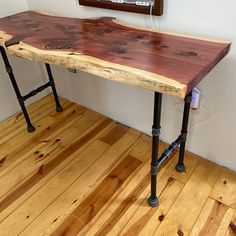 a wooden table sitting on top of a hard wood floor next to a white wall