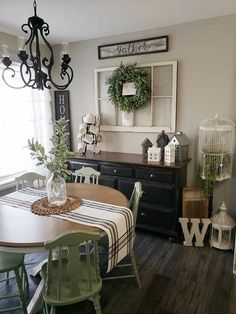 the dining room table is set with green chairs and a striped tablecloth on it