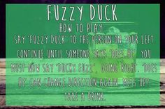 a glass filled with green liquid sitting on top of a wooden table next to a sign that reads fuzzy duck how to play