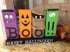 halloween decorations made out of wood blocks with faces and eyes on them sitting in hay