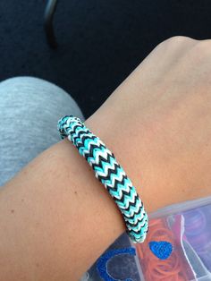 a close up of a person's arm wearing a bracelet with blue and white chevron