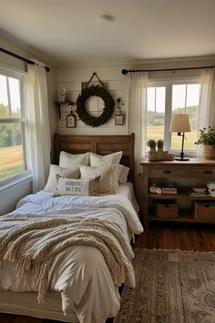 a bed sitting in a bedroom next to a window covered in white blankets and pillows