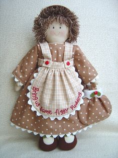 a brown and white doll wearing a dress with polka dots