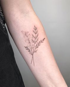 a woman's arm with a small flower tattoo on the left side of her arm