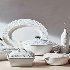 white dishes and utensils are arranged on a table