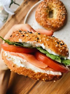 a bagel sandwich with salmon, lettuce and tomatoes