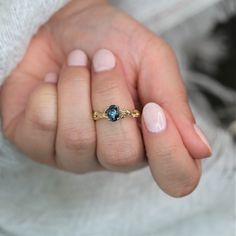 This engagement ring is perfect for those who are inspired by nature! This design is a real stunner. #rings #engagementrings #weddingrings #rosadosbox #gold #ocean #teal #tealsapphire #gemstone #diamonds #nature #artdeco #oval #unique #jewelry #gifts Exquisite Oval Sapphire Ring For Gift, Yellow Gold Sapphire Jewelry For Proposal, Oval Sapphire Jewelry For Proposal, Oval Sapphire Yellow Gold Wedding Ring, Oval Diamond Cut Sapphire Ring Fine Jewelry, 14k Gold Sapphire Ring With Rose Cut Diamonds, Oval Sapphire Ring In Yellow Gold For Proposal, Oval Sapphire Jewelry With Rose Cut Diamonds, Oval Gold Sapphire Ring With Diamond Cut