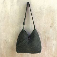 Vinita's flair for style and Thai elegance is evident in the modern design of this leaf green hobo bag. A removable coin purse adds to its versatile allure. Two exterior pockets are camouflaged among the diagonal pintucks that shape the cotton shoulder bag. The fully-lined interior includes two open pockets as well as a zipper pocket. The shoulder strap's length is adjustable and an ornate rain tree wood button closes the bag. Green Hobo Bag With Adjustable Strap For On-the-go, Green Rectangular Hobo Bag With Detachable Handle, Versatile Green Crossbody Hobo Bag, Green Crossbody Hobo Bag For Daily Use, Modern Green Pouch Shoulder Bag, Versatile Green Pouch Shoulder Bag, Versatile Green Hobo Bag, Green Bucket Bag With Removable Pouch For On-the-go, Everyday Green Hobo Bag With Adjustable Strap